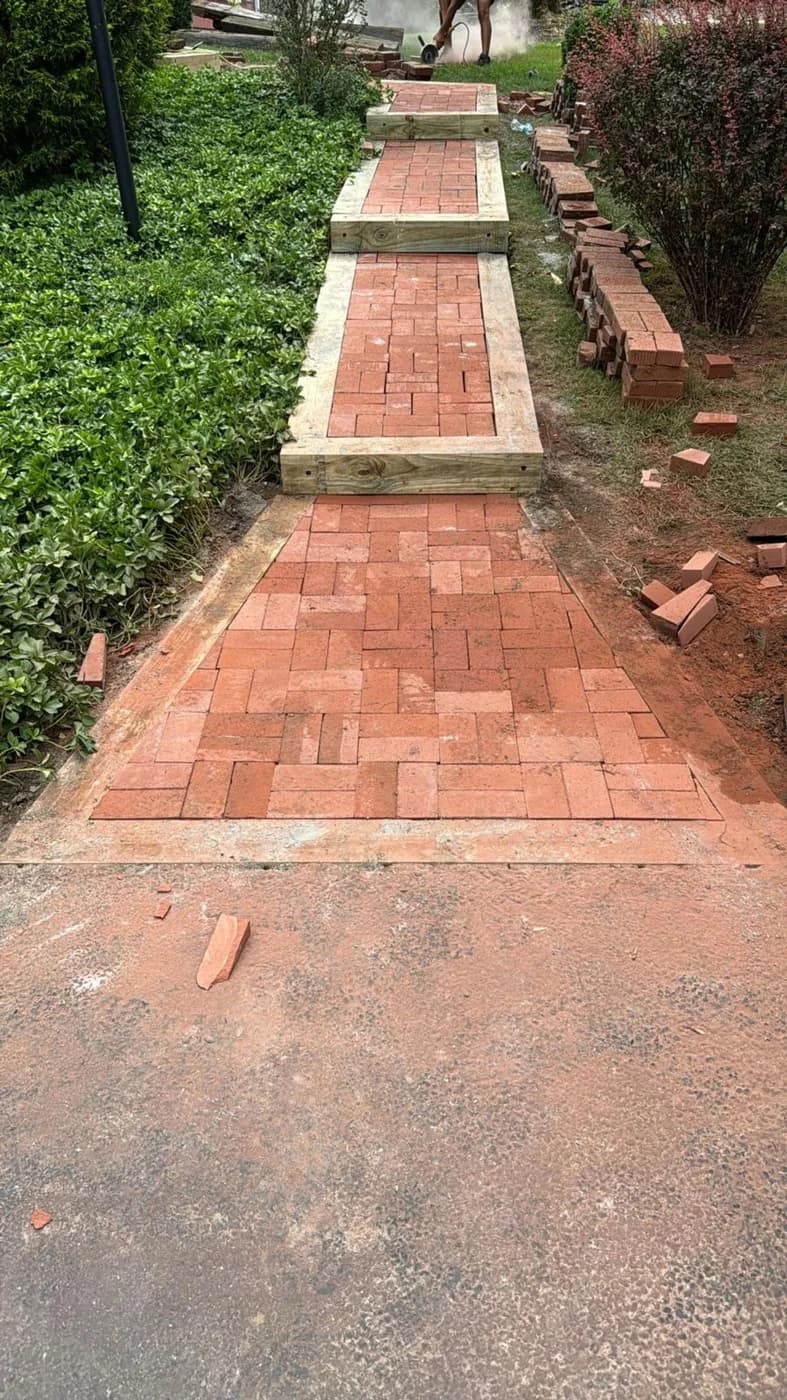 Long view of the same terraced red brick walkway through the garden