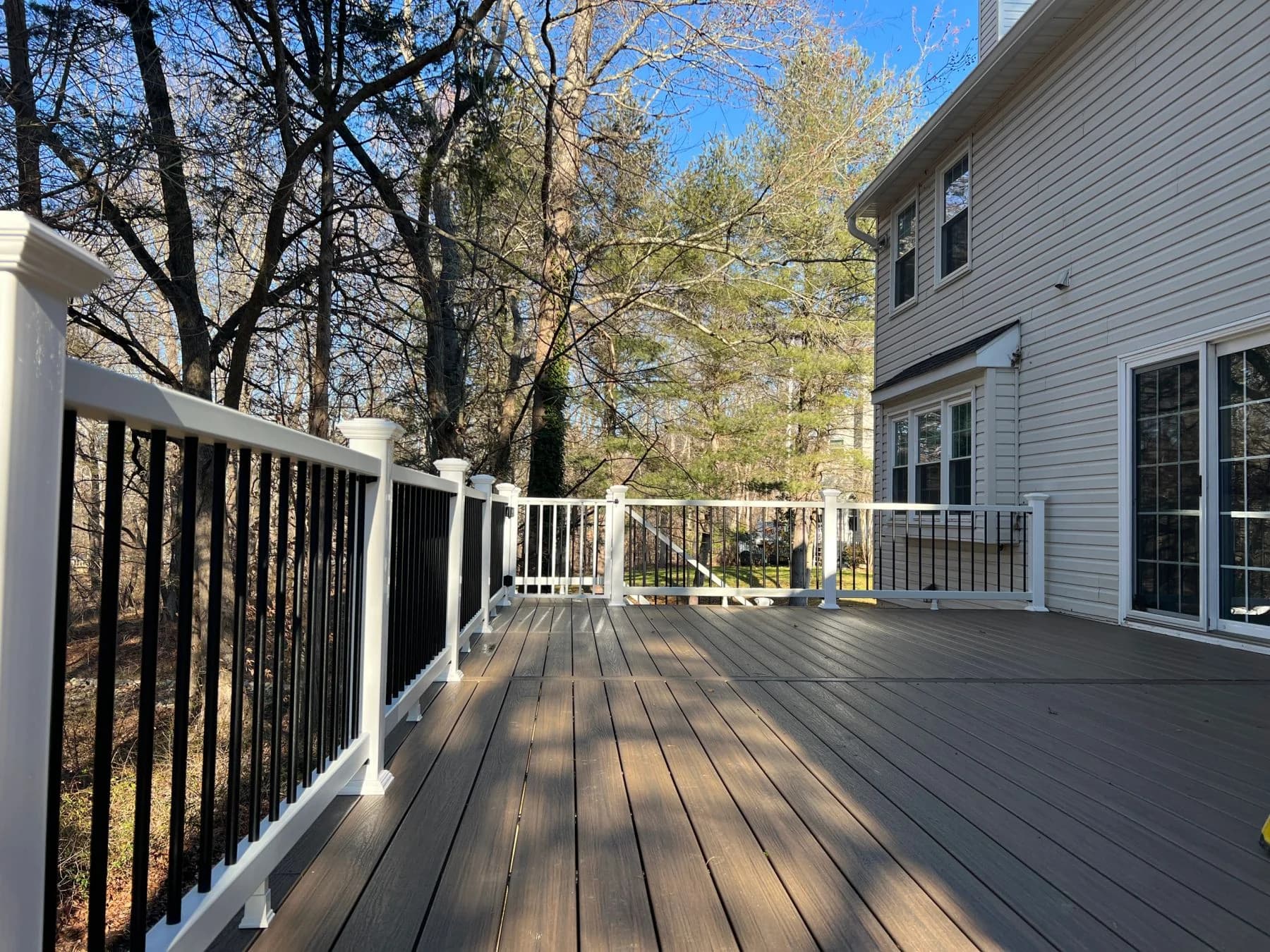 Wide view of the wood-toned upper deck beside the beige home