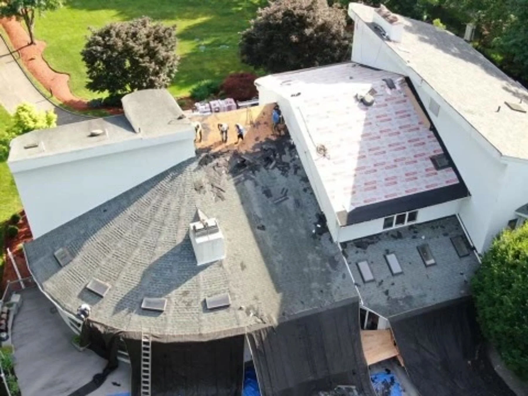 Aerial roofing progress view of the same white contemporary home