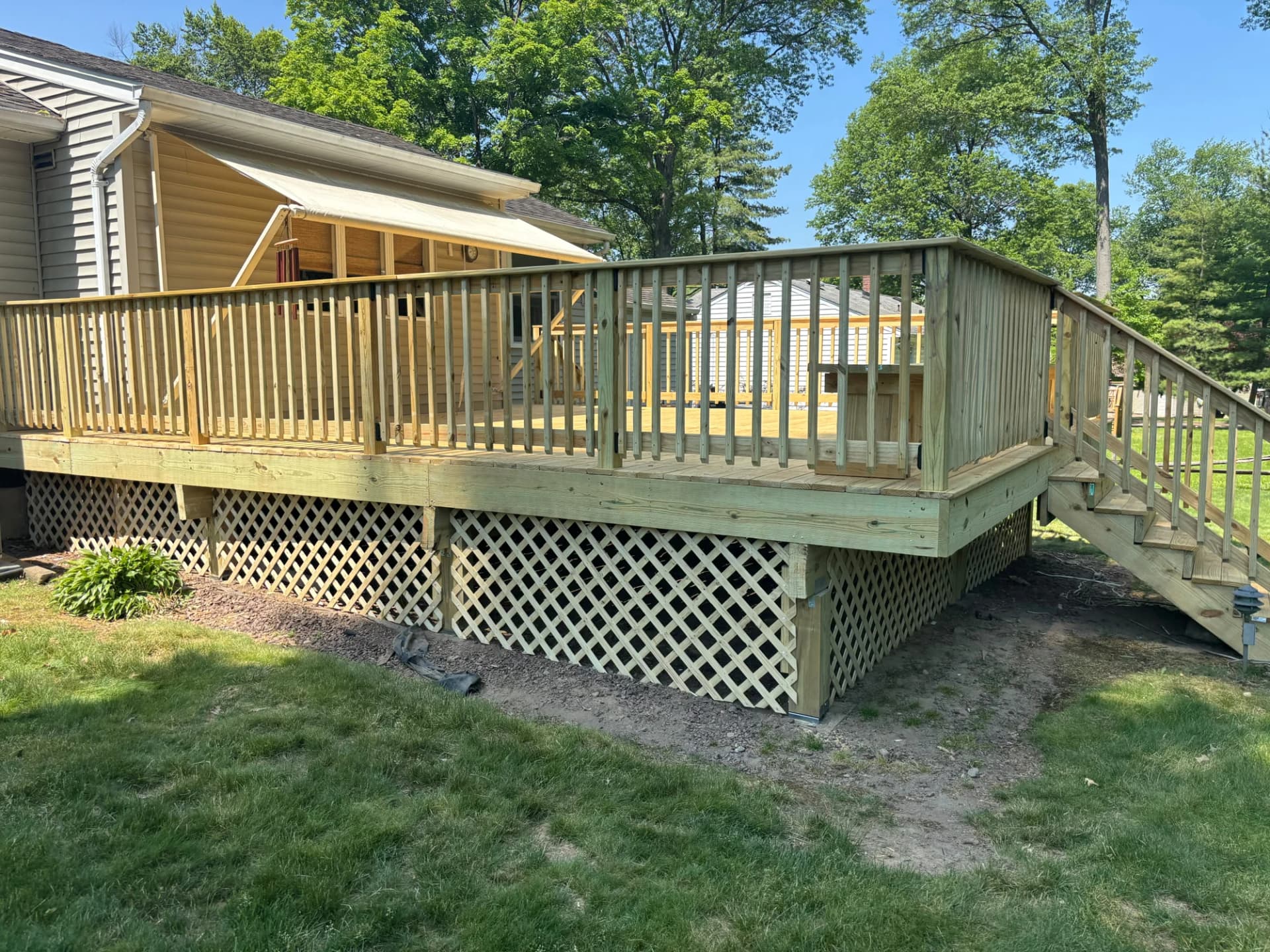Side view of the natural timber deck, straight timber railings and yard-facing stairs